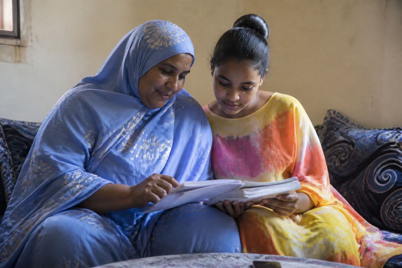 Mère et adolescente mauritaniennes qui regardent ensemble les cahiers scolaires
